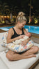 Baby resting on the Mamora nursing pillow by the pool